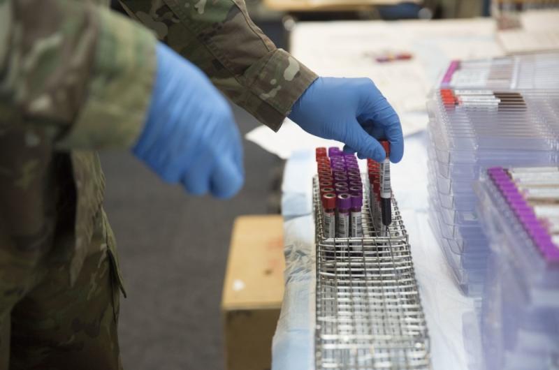 A military medicine professional inserting vials in a case.