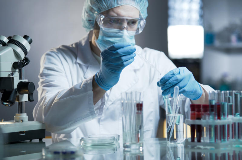 A photo of a scientist in PPE conducting an experiment.